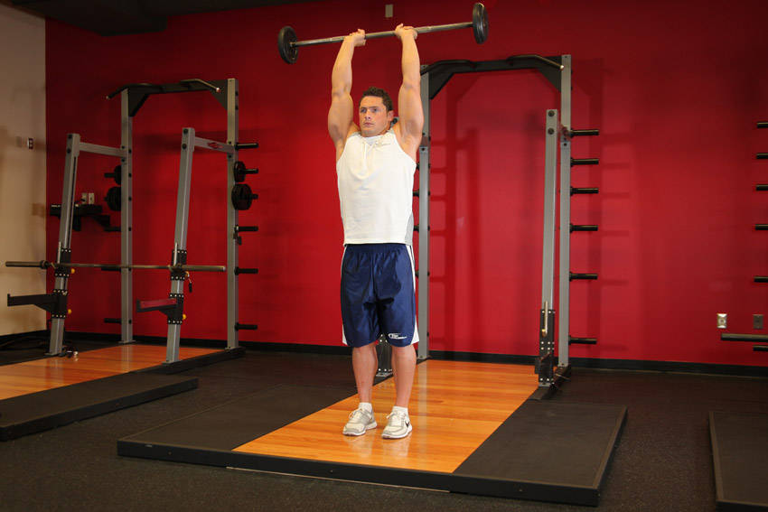 Standing Overhead Barbell Triceps Extension, end position